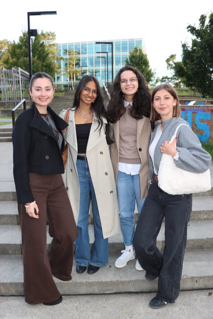 Four student representatives posing together on steps outside an FHNW campus building