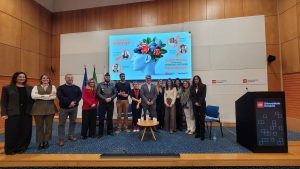 Group photo of participants on the auditorium stage beneath the M.A.R.K.E.T. Meet-Up slide on mental health and psychological first aid, with Universidade Europeia branding.