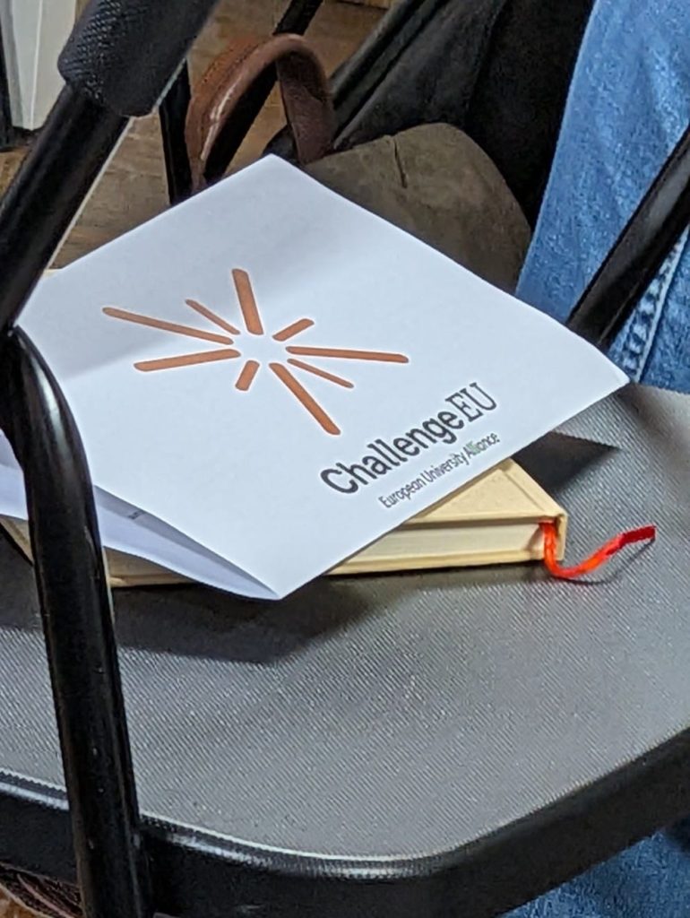 Printed ChallengeEU materials placed on a chair during a training session, featuring the ChallengeEU logo.
