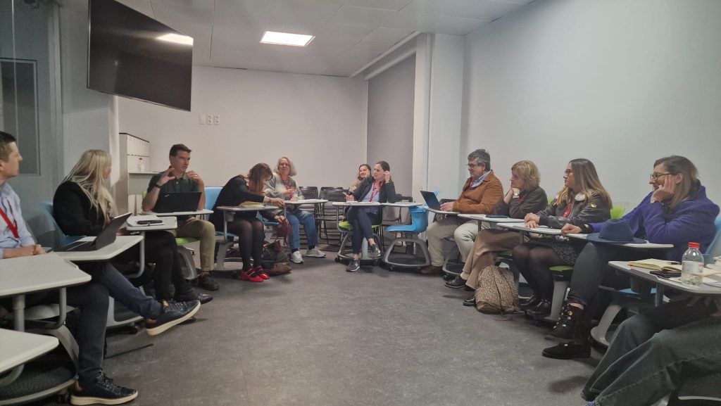 Group discussion in a classroom, with participants seated in a circle and actively exchanging ideas during a workshop.