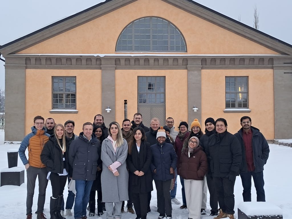 Group photo of participants standing in the snow in front of a university building during the ChallengeEU visit to MIUN in Östersund.