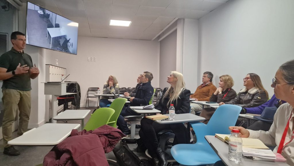 Workshop session with a trainer presenting content to a seated audience in a classroom setting.