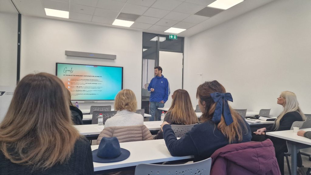 Workshop participant presents learning goals during a Challenge Based Learning session, while attendees listen and take notes.