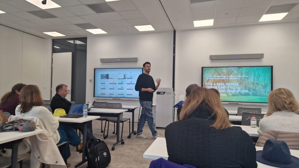 Trainer explains the principles of Challenge Based Learning to academic staff seated in a classroom setting.