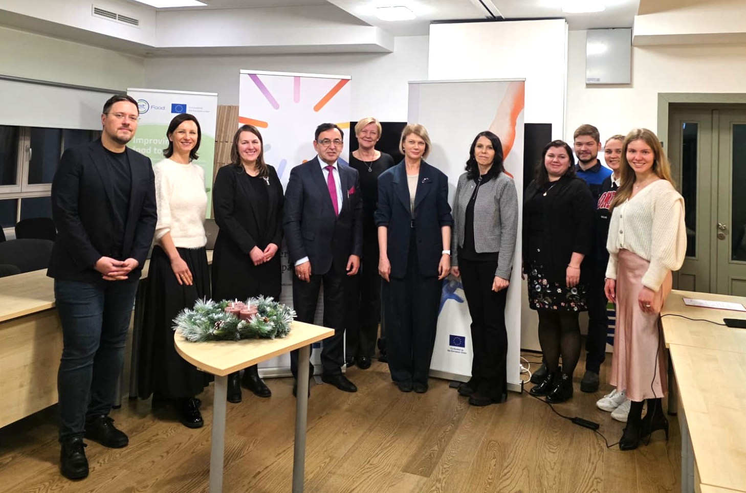 Group photo of eleven participants at a ChallengeEU meeting at LBTU’s Technology and Knowledge Transfer Centre, standing between roll-up banners (including EU/ChallengeEU branding); a small table with a winter wreath and candles is in the foreground