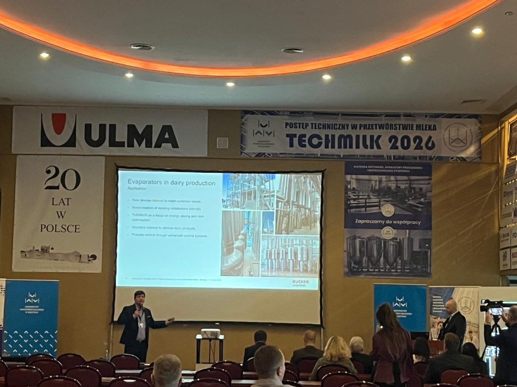 Speaker presenting dairy processing technologies during a Techmilk 2026 session, with attendees seated in front of a large presentation screen.