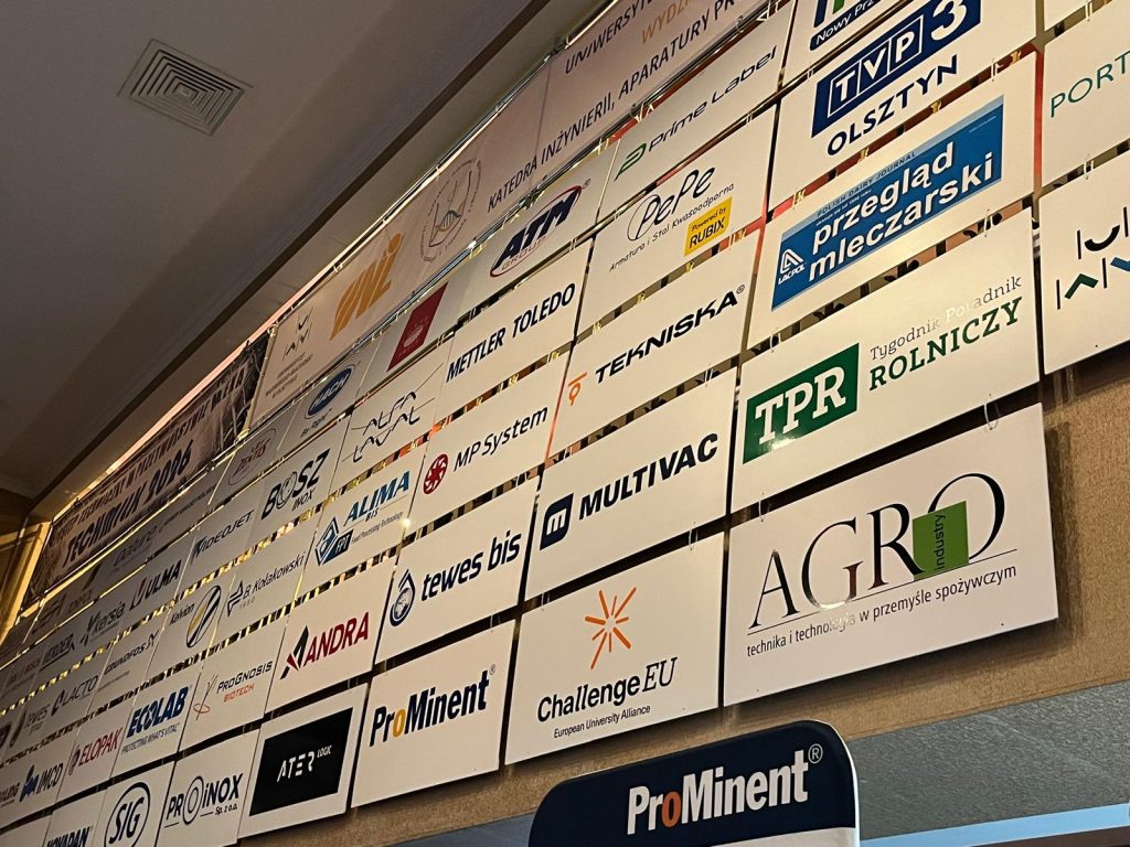 Wall of partner and sponsor logos at Techmilk 2026, including industry, media and academic organisations.