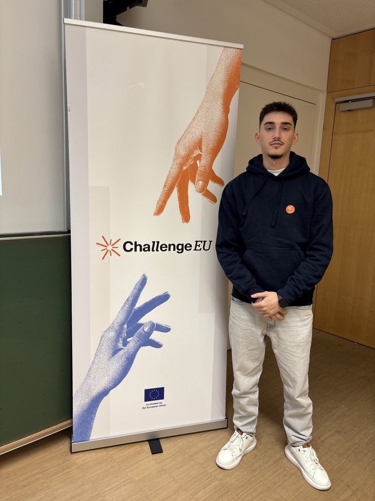 Gajur Memeti stands next to the ChallengeEU roll-up banner
