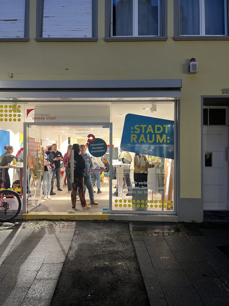 ChallengeEU poster displayed in the Stadtraum Offenburg window reading “9 Partner, eine Vision. Gemeinsam für die Zukunft Europas,” with workshop participants visible inside.