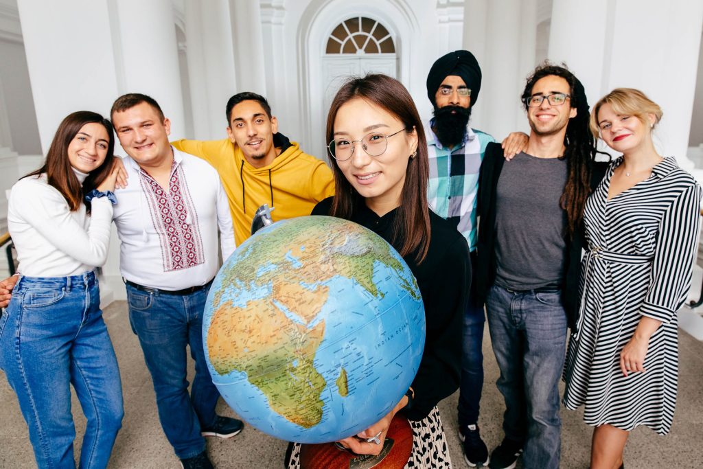 A group of young people, one of them holding a globe.