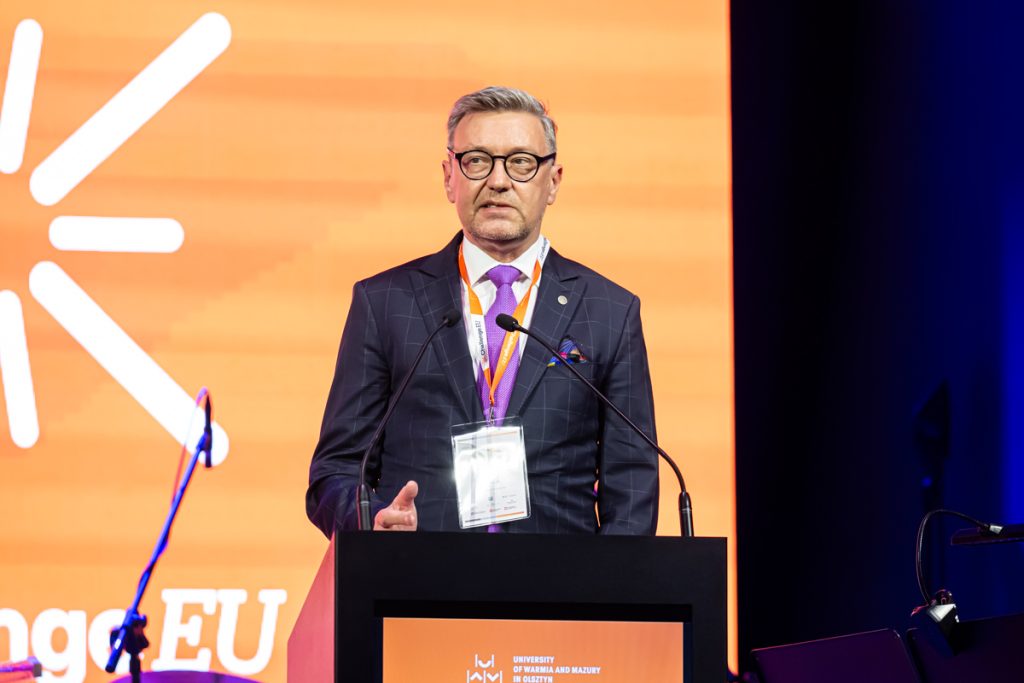 A speaker stands at the podium during the ChallengeEU 1st Annual Conference opening session, with a large ChallengeEU screen behind him.