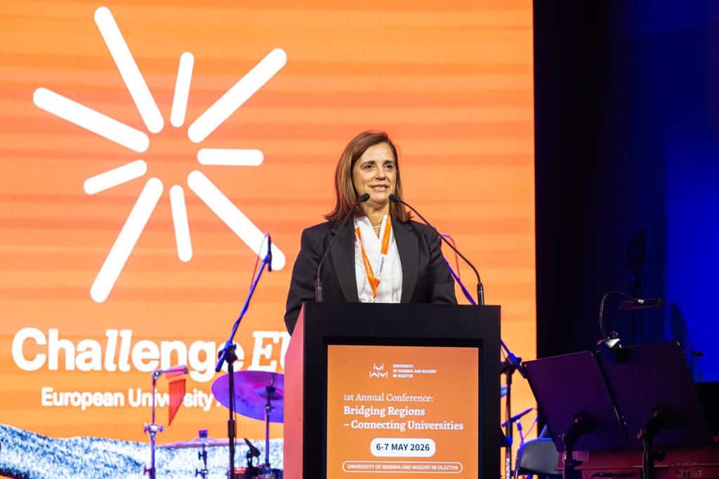 A speaker stands at the podium during the ChallengeEU 1st Annual Conference opening session, with a large ChallengeEU screen behind her.