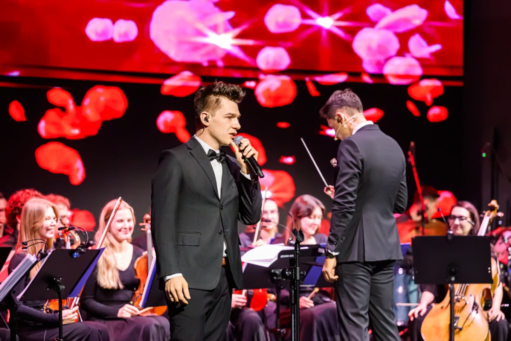 A vocalist and orchestra perform on stage during the artistic part of the ChallengeEU 1st Annual Conference.