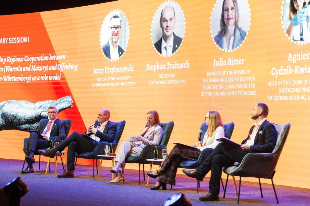 Panel discussion during the ChallengeEU 1st Annual Conference, with speakers seated on stage and one panellist speaking into a microphone