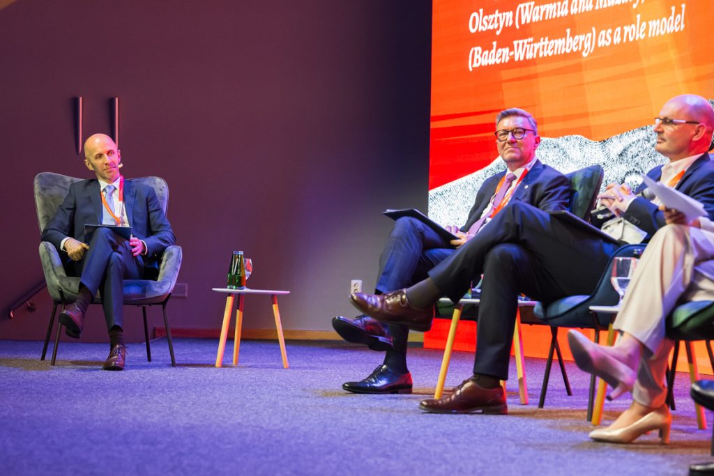 Panel discussion during the ChallengeEU 1st Annual Conference, with speakers seated on stage and one panellist speaking into a microphone