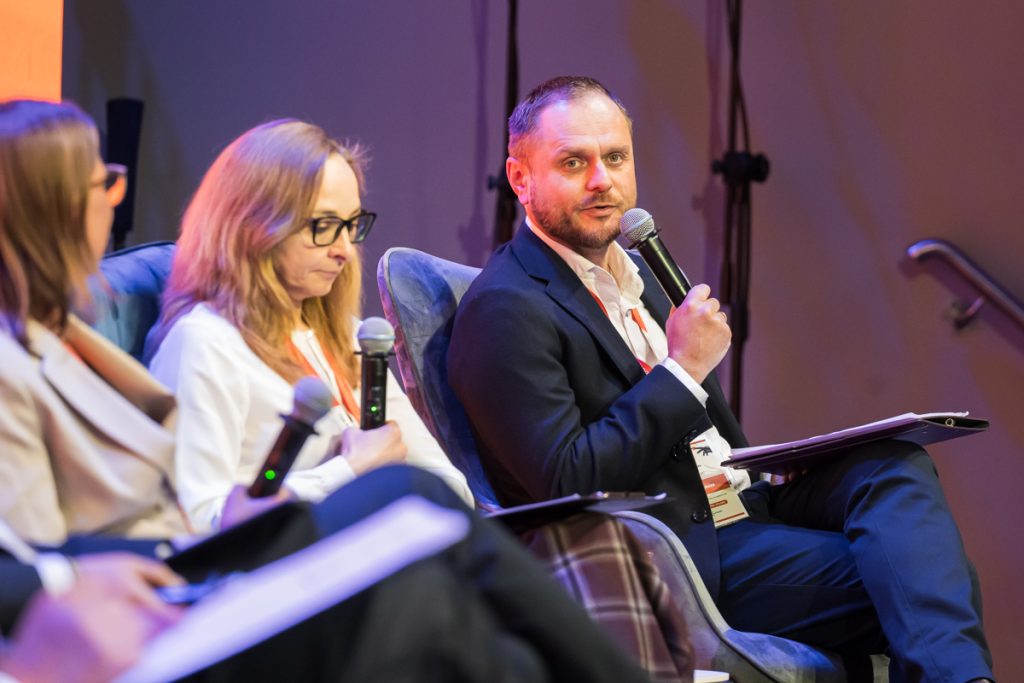 Panel discussion during the ChallengeEU 1st Annual Conference, with speakers seated on stage and one panellist speaking into a microphone