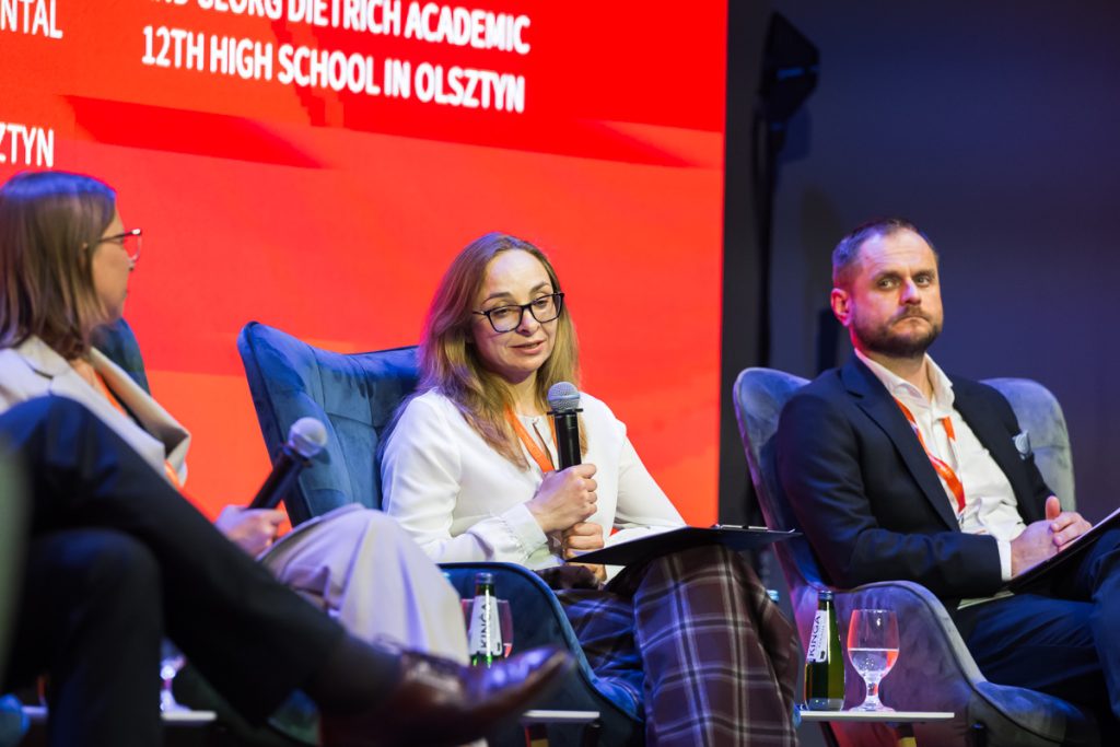 Panel discussion during the ChallengeEU 1st Annual Conference, with speakers seated on stage and one panellist speaking into a microphone