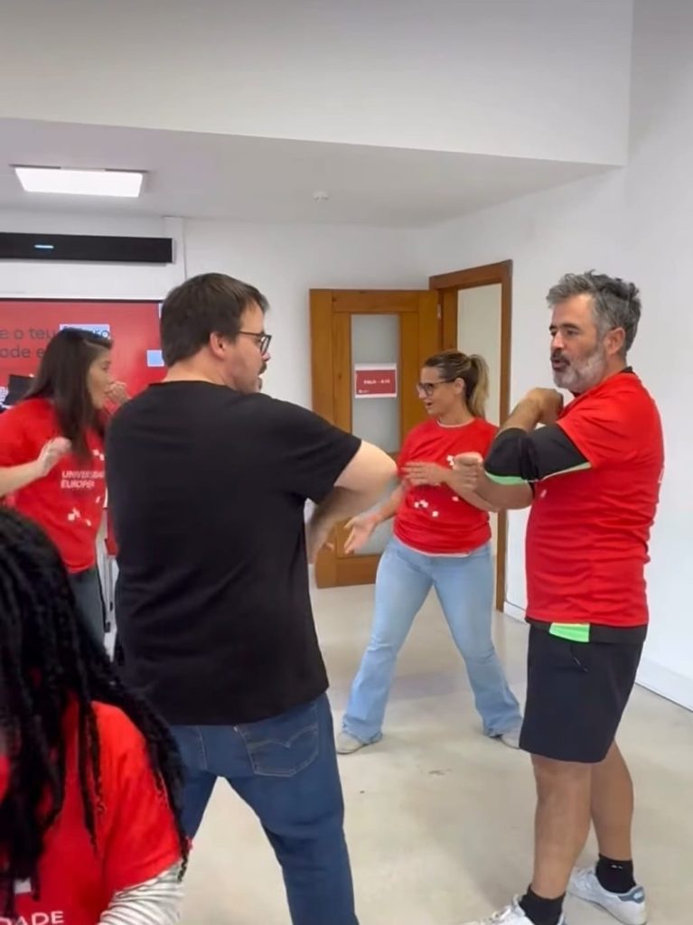 The picture shows three people who are taking part in self-defence training at Universidade Europeia de Lisboa. 