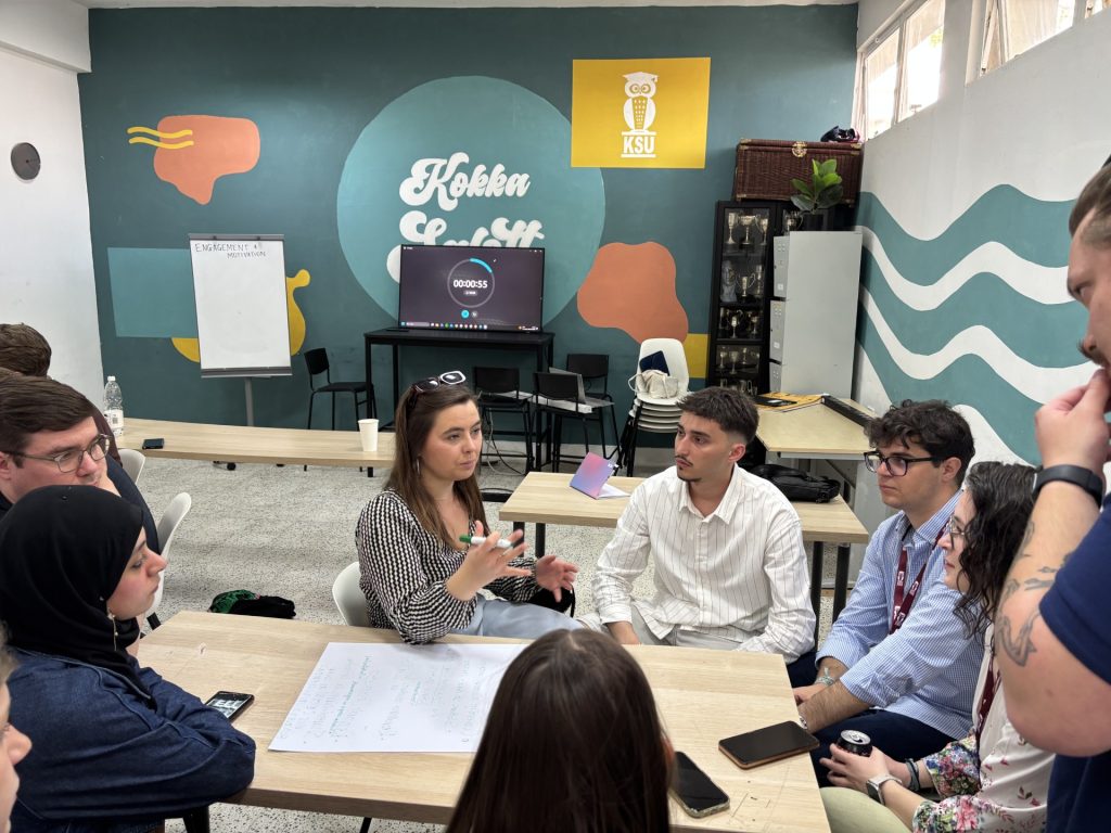 Gajur sits at a table with other students during a discussion.