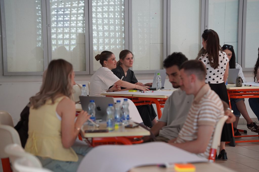 Groups of students sit at tables and discuss their ideas during the ChallengeEU Hackathon.