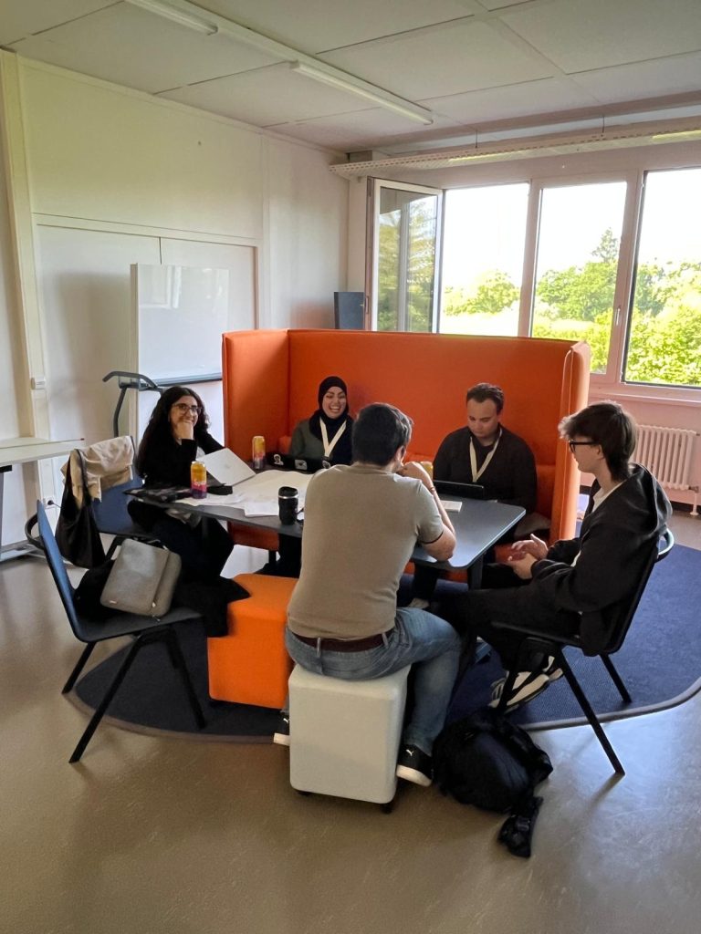 Students discuss ideas in a small group during a workshop session.