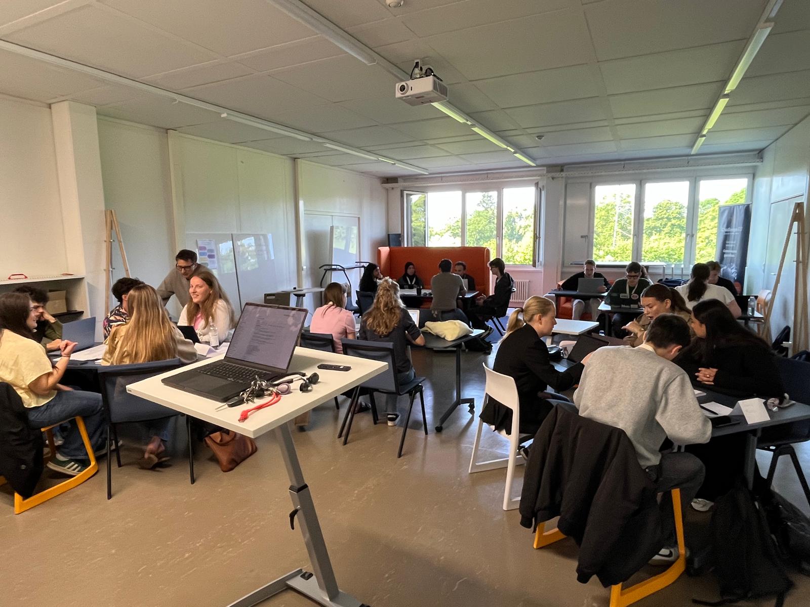 Students take part in a workshop session in a classroom, with a presentation displayed on the screen.