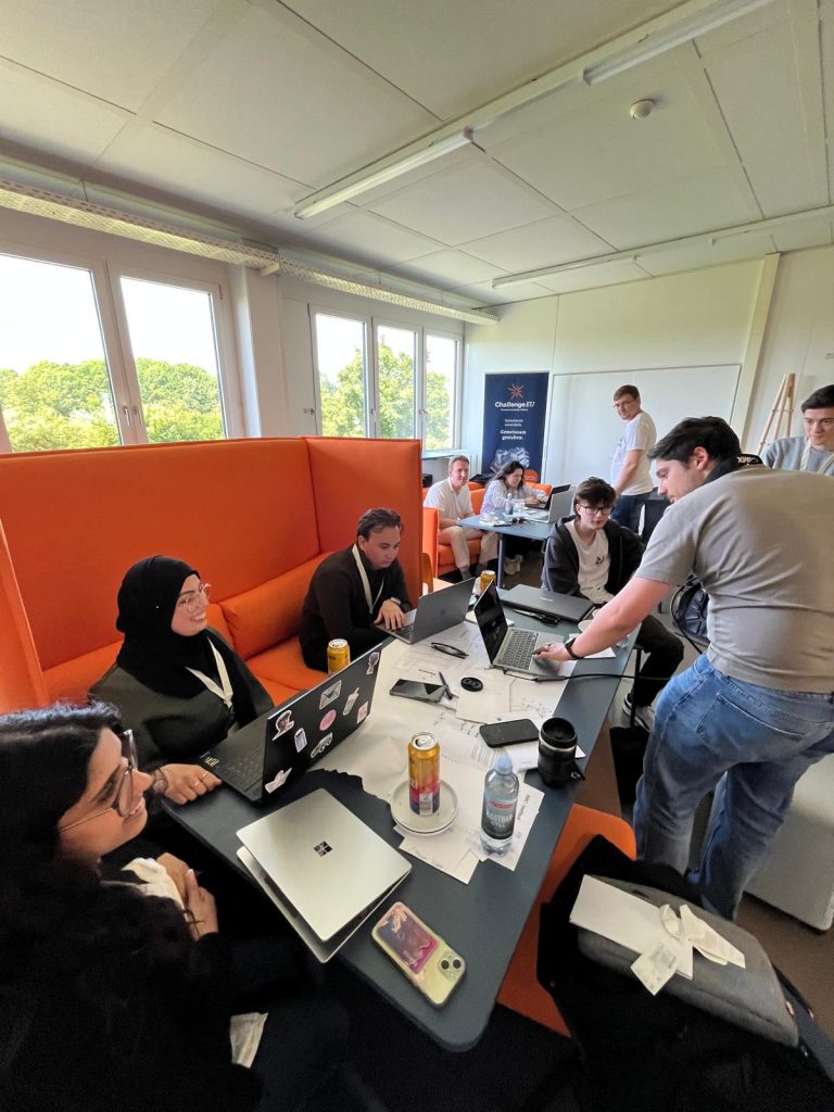 Students work in teams with laptops during a ChallengeEU hackathon session.