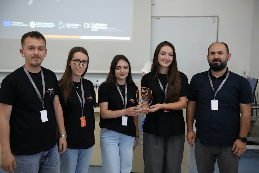 A student team and mentor pose with the Best Business Idea award at the ChallengeEU Hackathon.
