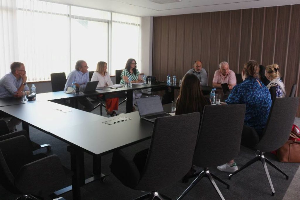 The people taking part in the meeting are sitting at a tabl