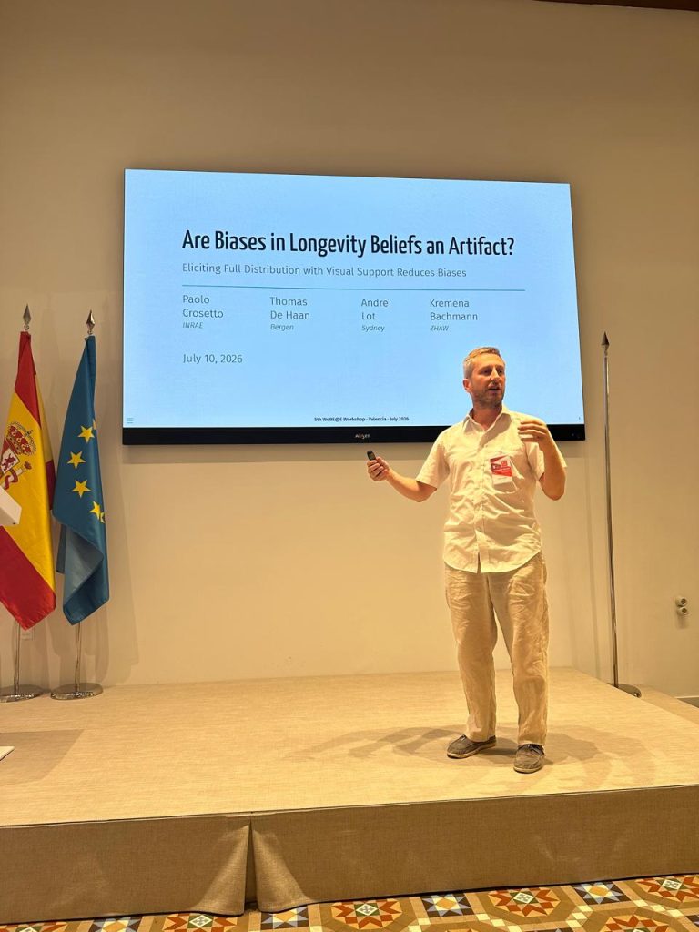 Researcher presenting a study on biases in longevity beliefs during the WoBE Research Workshop in Valencia.
