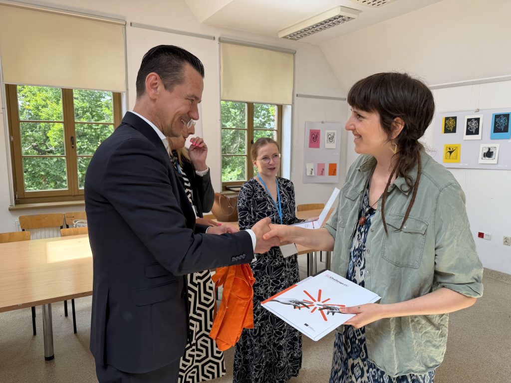 A participant receives a certificate during the closing ceremony of the ChallengeEU Traces in the Landscape Summer School at the University of Warmia and Mazury.